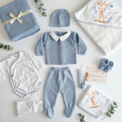 Conjunto de roupa de bebé com peças azuis e brancas e toalha com girafa estampada