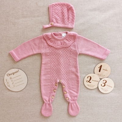 Conjunto de bebé rosa em malha com macacão e gorro e discos de madeira com meses e texto Cheguei