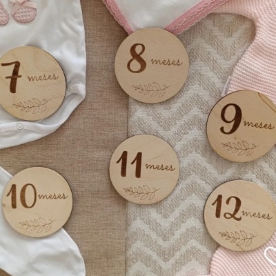 Discos de madeira redondos gravados com números e meses sobre tecidos coloridos