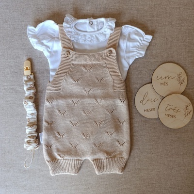 Conjunto bebé com body branco, jardineira castanha, clip para chupeta e placas de madeira com meses.