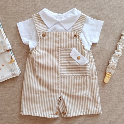 Conjunto de roupa de bebé com camisa branca e jardineira às riscas beges