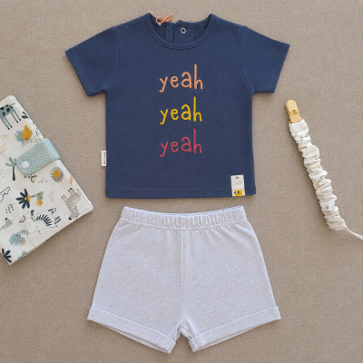 Conjunto de roupa infantil t-shirt azul com palavras yeah em várias cores e calções cinza claro