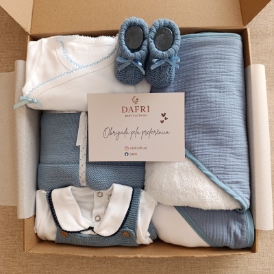 Caixa de presente com roupa e acessórios de bebé em tons azul e branco