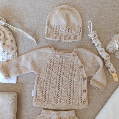 Conjunto de roupa de bebé em malha bege com padrão trançado