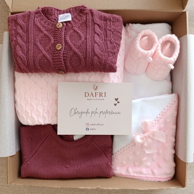 Conjunto de roupa de bebé em caixa com camisolas de malha bordô e rosa, manta rosa, sapatinhos de lã rosa e cartão de agradecimento Dafri