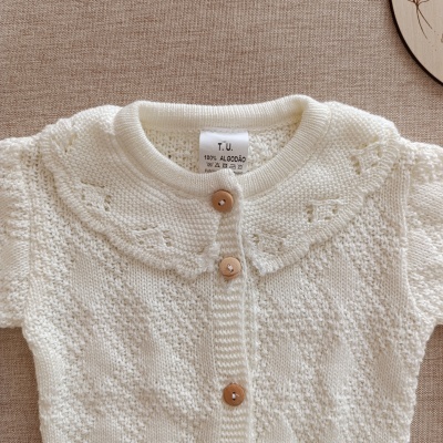 Camisola de bebé branca de algodão com botões de madeira e padrão de malha