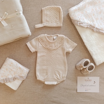 Conjunto de roupa de bebé em tons neutros com body, touca, sapatinhos, manta e cartão de agradecimento