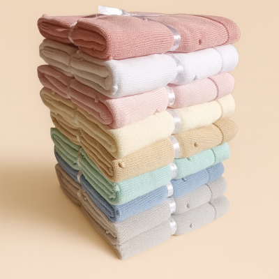 Pilhas de mantas de malha em várias cores pastel