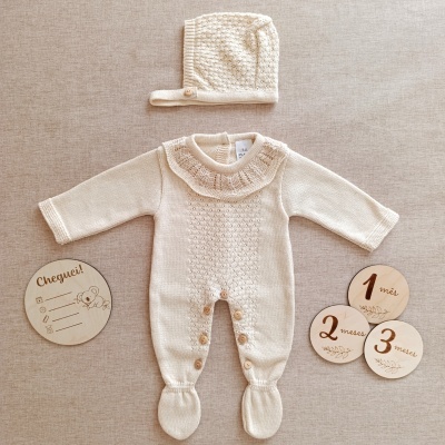 Conjunto de bebé creme com macacão e capuz, e placas de madeira para meses