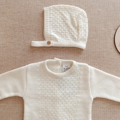 Conjunto de bebé branco em algodão com camisola e touca malhada.