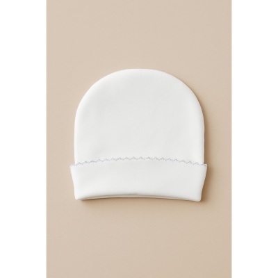 Gorro branco para bebé com costura azul em fundo bege
