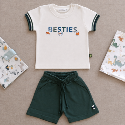Conjunto infantil com t-shirt branca estampada e calções verdes.