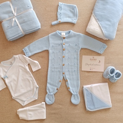 Conjunto de roupa e acessórios para bebé azul claro e branco com babygrow, gorro, manta, body, leggings e sapatinhos.