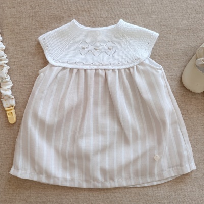 Vestido de bebé branco com malha tricotada na parte superior e tecido riscado na parte inferior