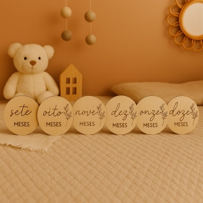 Placas de madeira com números e meses, ursinho, móbile e espelho no quarto de bebé