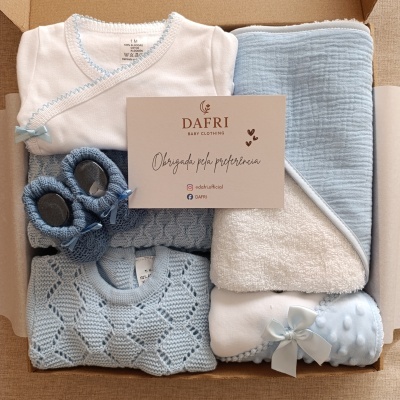 Conjunto de roupa de bebé azul e branca numa caixa com cartão DAFRI BABY CLOTHING