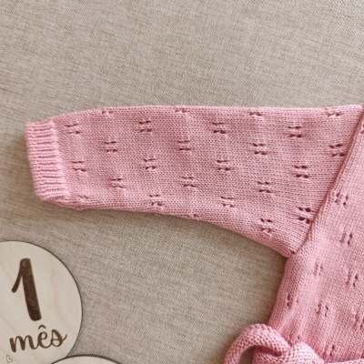 Manga rosa tricotada com padrão de buracos e calendário 1 mês em madeira