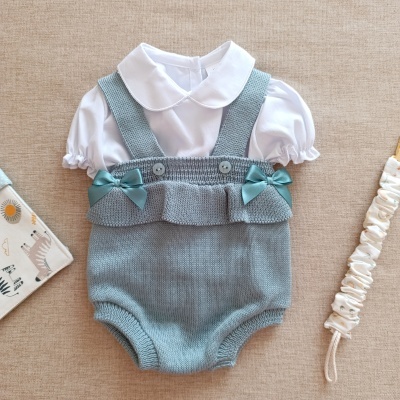 Conjunto de bebé com body branco e jardineira cinza azulada de malha com laços