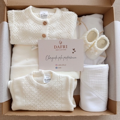Conjunto de roupa de bebé em algodão branco com cardigã, body, sapatinhos e manta numa caixa de cartão