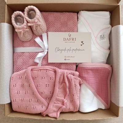 Caixa de oferta com roupas de bebé rosa e branco e cartão da marca DAFRI