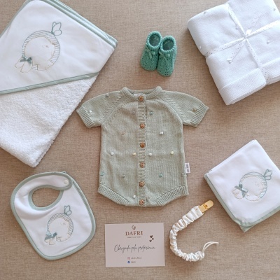 Roupas e acessórios para bebé em tons verde água e branco com detalhes bordados e cartão de marca DAFRI.