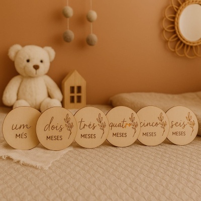 Discos de madeira com meses do bebê em português, urso de pelúcia e decoração de quarto em tons bege