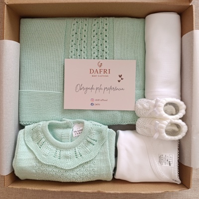 Conjunto de roupa de bebé verde água e branco embalado numa caixa de cartão