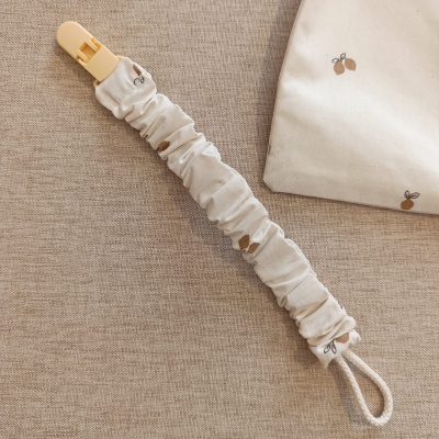 Clipe de tecido elástico bege com padrão de frutas pequenas e gancho de plástico amarelo