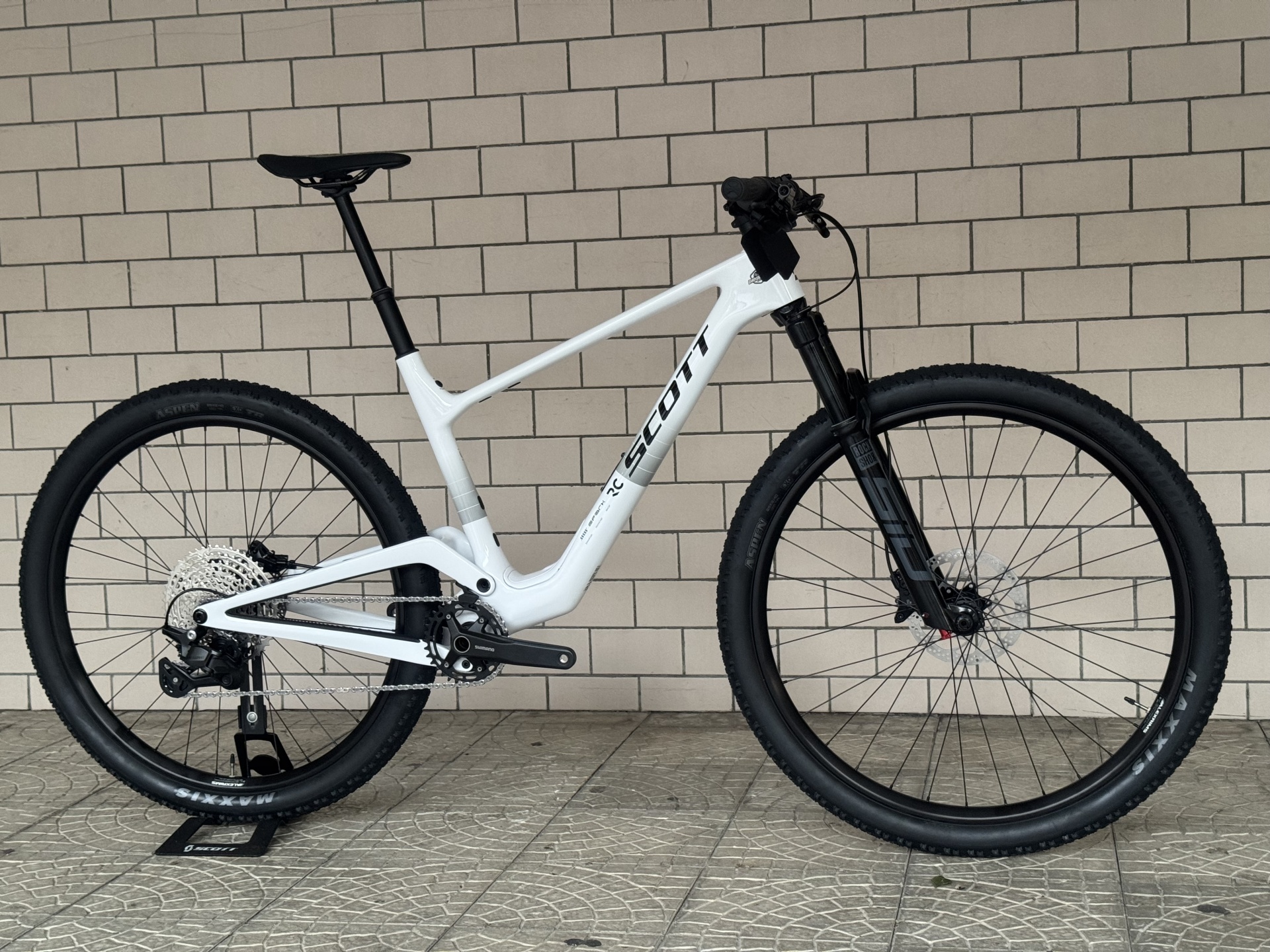BICICLETA SCOTT SPARK RC COMP - 27 Bicicleta de montanha branca da marca SCOTT encostada a parede de tijolos