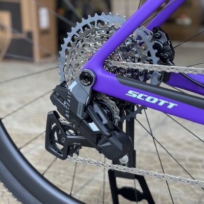 Sistema de transmissão traseiro de bicicleta roxa SCOTT com cassete metálico e câmbio SRAM XPLR