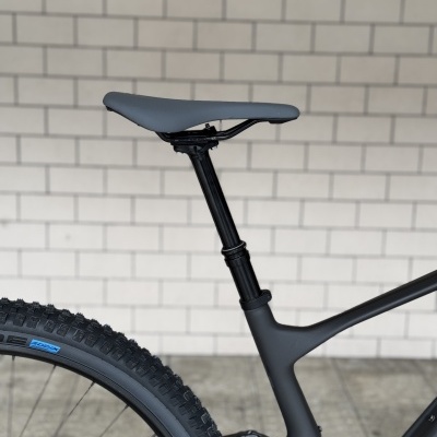 Assento e canote de bicicleta de montanha preta junto a parede branca de azulejos