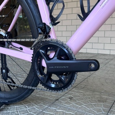 Bicicleta de estrada cor-de-rosa com partes negras e texto ULTEGRA