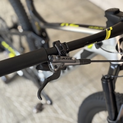 Guiador preto de bicicleta com manete de travão XTR e quadro cinzento e branco com amarelo