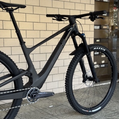 Bicicleta de montanha preta com pneus Maxxis e quadro em carbono