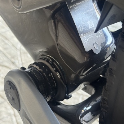 Componente traseiro de bicicleta preta com etiqueta cinza de instruções e símbolos de reciclagem