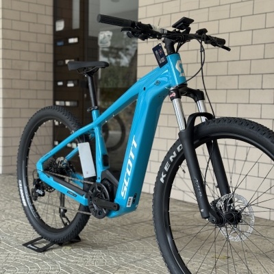Bicicleta eléctrica Scott azul com pneus pretos e suspensão dianteira