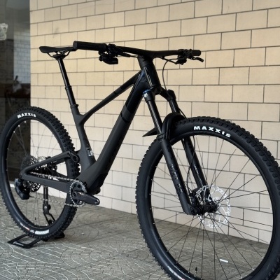 Bicicleta de montanha preta com pneus MAXXIS e suspensão dianteira