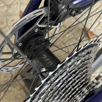 Roda de bicicleta com disco de travão, cassete metálica e cubo com texto DT SWISS 240.