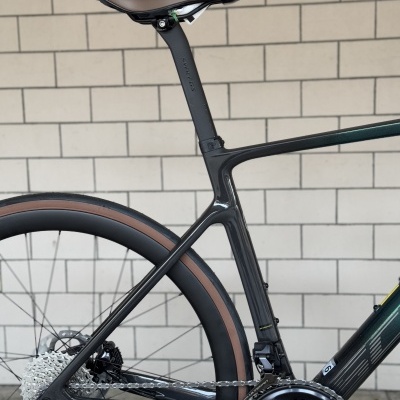 Parte traseira de bicicleta de estrada com quadro carbono preto e selim castanho