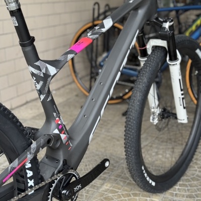 Bicicleta de montanha cinza com detalhes geométricos em piso mosaico