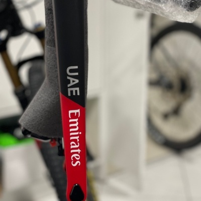Braço de bicicleta preta e vermelha com as palavras UAE e Emirates