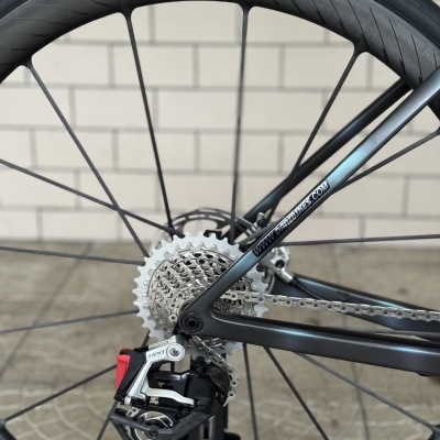 Roda traseira de bicicleta com pneu Schwalbe Pro One e desviador traseiro vermelho e prateado