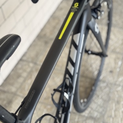 Bicicleta de estrada preta com detalhes amarelos e brancos e logótipos da marca SCOTT