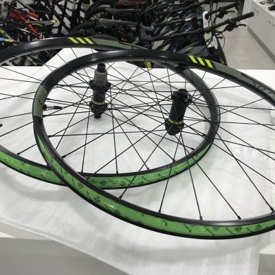 Par de rodas de bicicleta verdes e pretas sobre superfície branca