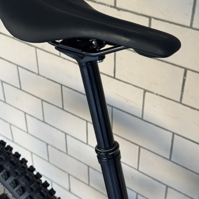 Banco para bicicleta preto com texto TOFINO junto a parede de azulejos brancos