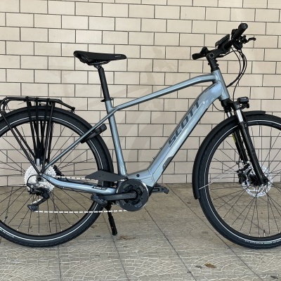 Bicicleta elétrica de montanha cinza com pneus pretos e suspensão dianteira