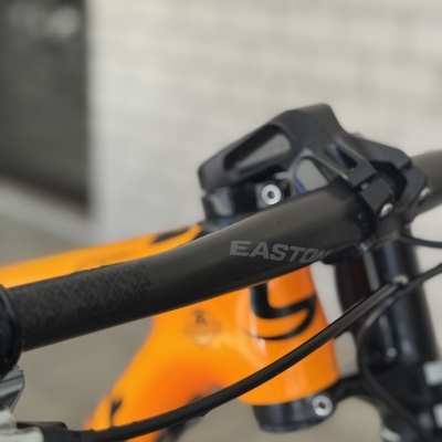 Guiador preto de bicicleta EASTON com quadro laranja e cabos visíveis