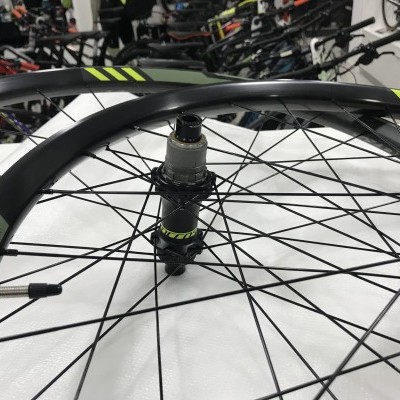 Roda de bicicleta preta com detalhes verdes numa loja de bicicletas