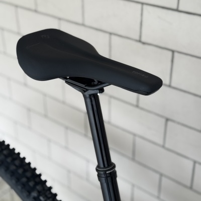 Selim de bicicleta preto com inscrição TOFINO em branco e canote preto