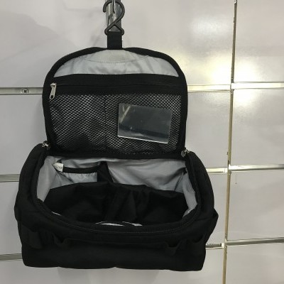 Bolsa organizadora preta de tecido aberta, com compartimentos internos e rede de malha